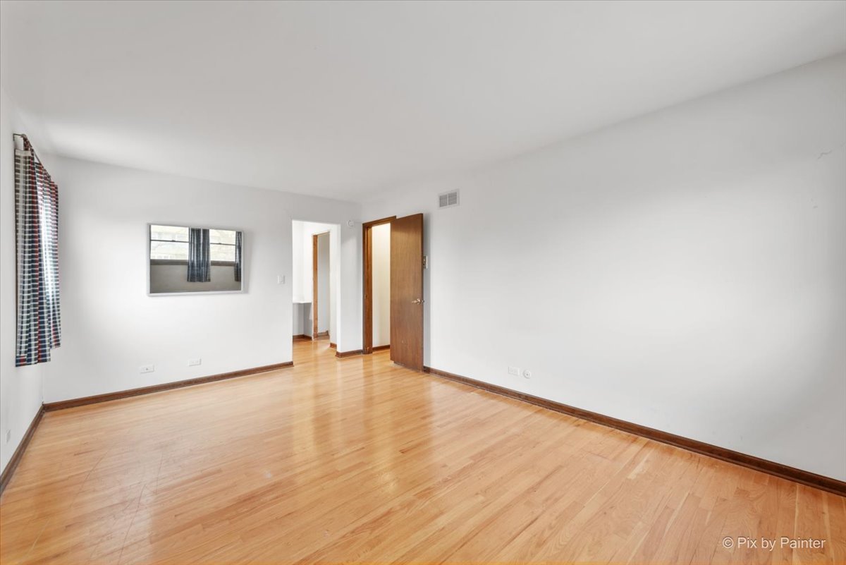 1100 South Church Road Mount Prospect, IL 60056 - Photo 18 of 50 a view of an empty room with wooden floor and a window