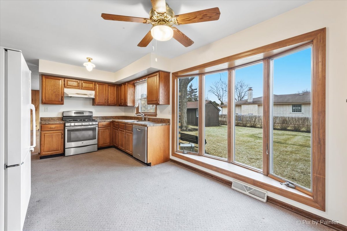 1100 South Church Road Mount Prospect, IL 60056 - Photo 8 of 50 a kitchen with stainless steel appliances a stove top oven a sink and a refrigerator