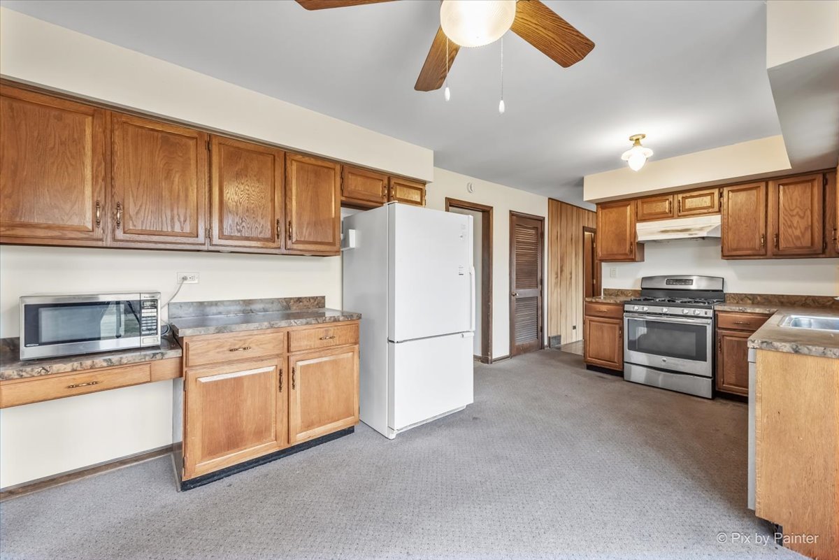 1100 South Church Road Mount Prospect, IL 60056 - Photo 9 of 50 a kitchen with stainless steel appliances granite countertop a refrigerator and a stove