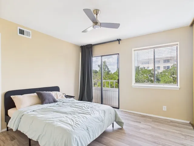 a bedroom with a bed and wooden floor