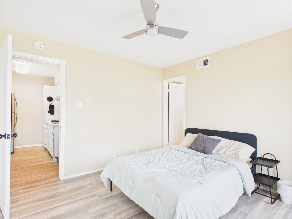 3115 Helms Street, Unit 202 Austin, TX 78705 - Photo 12 of 26 a bedroom with a bed and wooden floor
