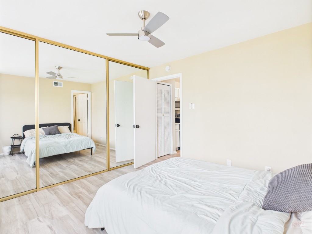 3115 Helms Street, Unit 202 Austin, TX 78705 - Photo 13 of 26 a bedroom with a bed and a chandelier