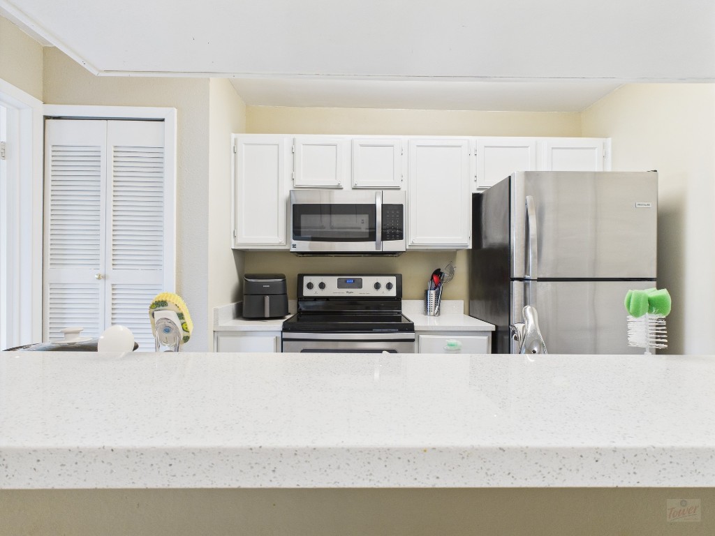 3115 Helms Street, Unit 202 Austin, TX 78705 - Photo 18 of 26 a kitchen with stainless steel appliances a microwave a sink and a refrigerator