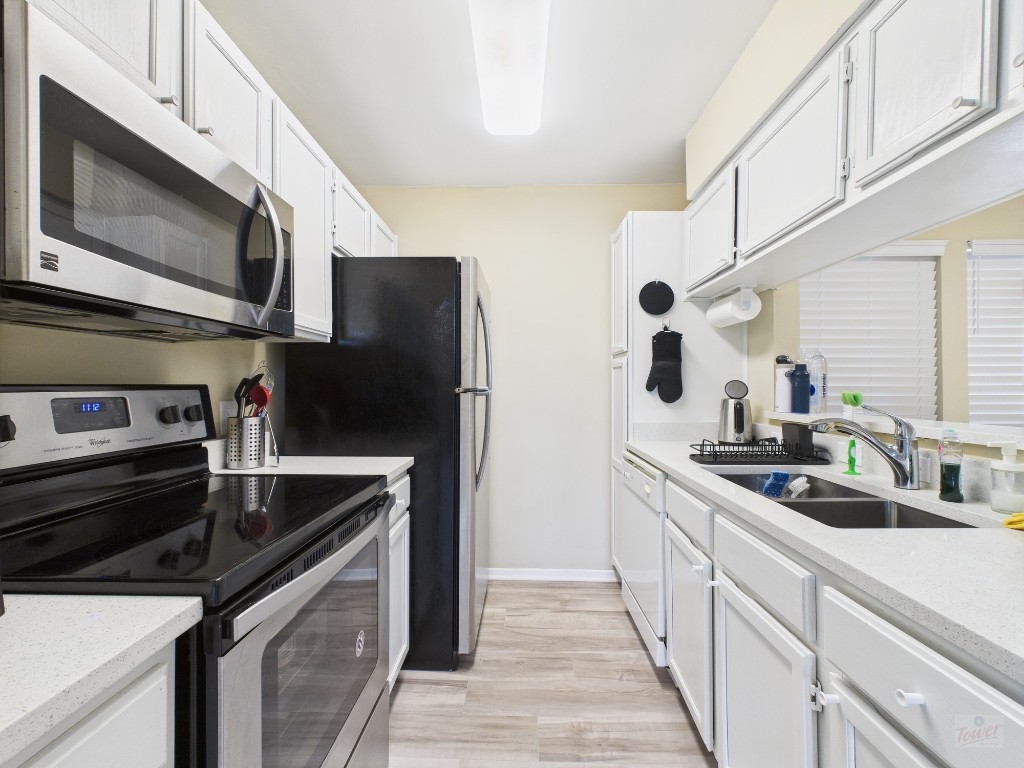 3115 Helms Street, Unit 202 Austin, TX 78705 - Photo 19 of 26 a kitchen with stainless steel appliances a sink stove and microwave