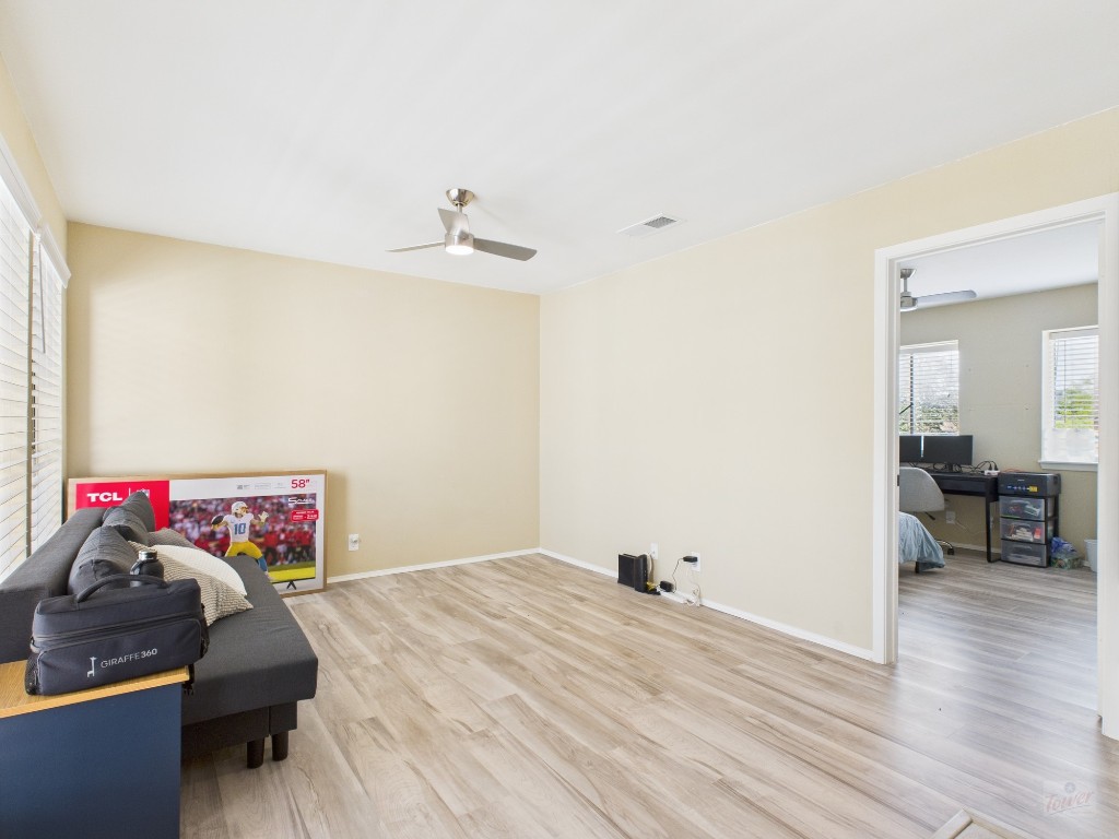 3115 Helms Street, Unit 202 Austin, TX 78705 - Photo 4 of 26 a bedroom with a bed and a wooden floor