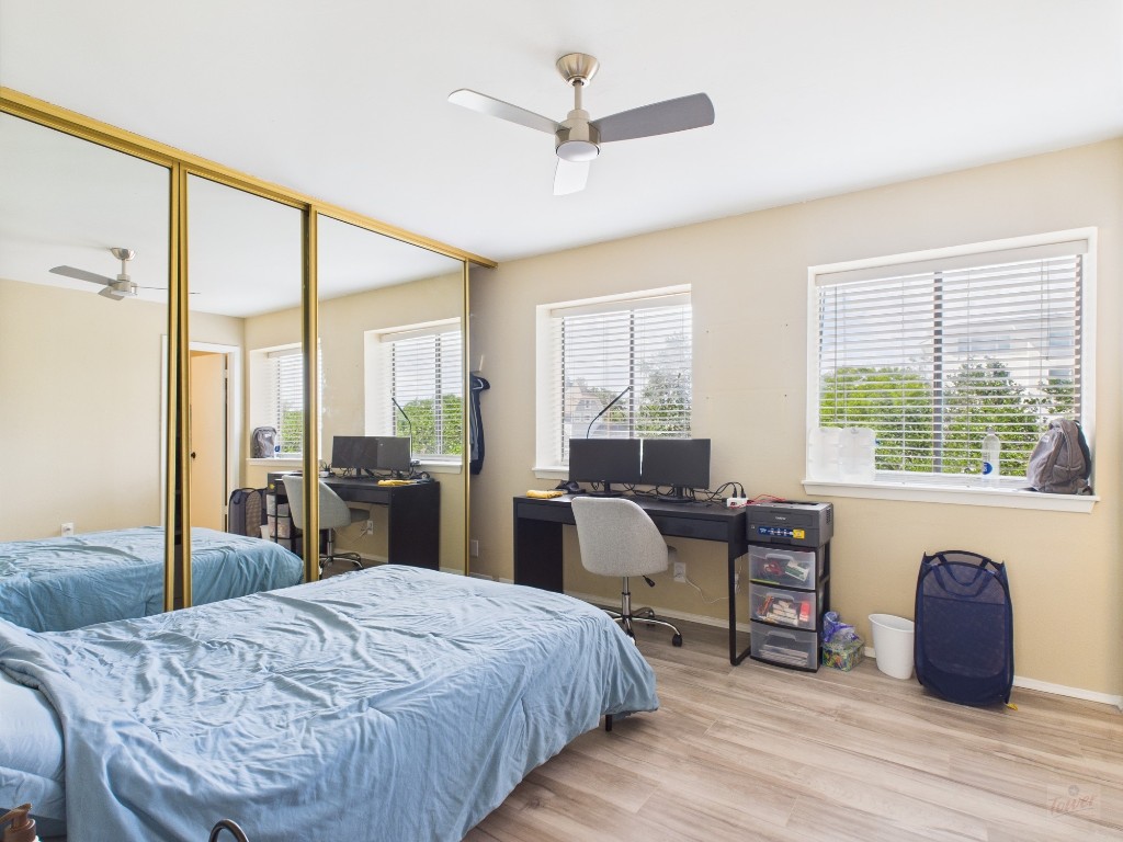 3115 Helms Street, Unit 202 Austin, TX 78705 - Photo 5 of 26 a bed room with a bed and wooden floor