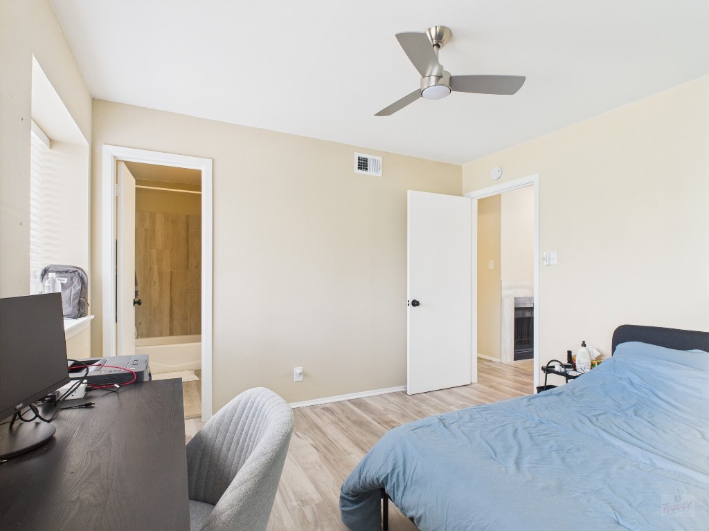 3115 Helms Street, Unit 202 Austin, TX 78705 - Photo 6 of 26 a bedroom with a bed and a flat screen tv