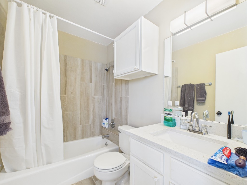 3115 Helms Street, Unit 202 Austin, TX 78705 - Photo 7 of 26 a bathroom with a sink a toilet and shower curtain