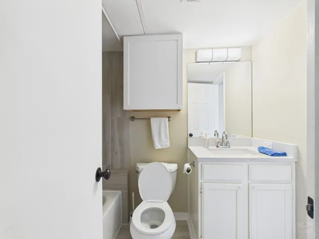 a bathroom with a sink a toilet a mirror and shower