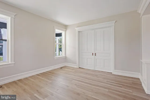 a view of empty room with wooden floor and window