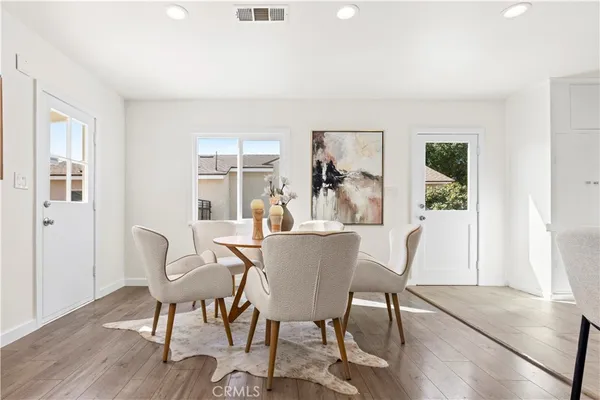 a dining room with furniture window and wooden floor