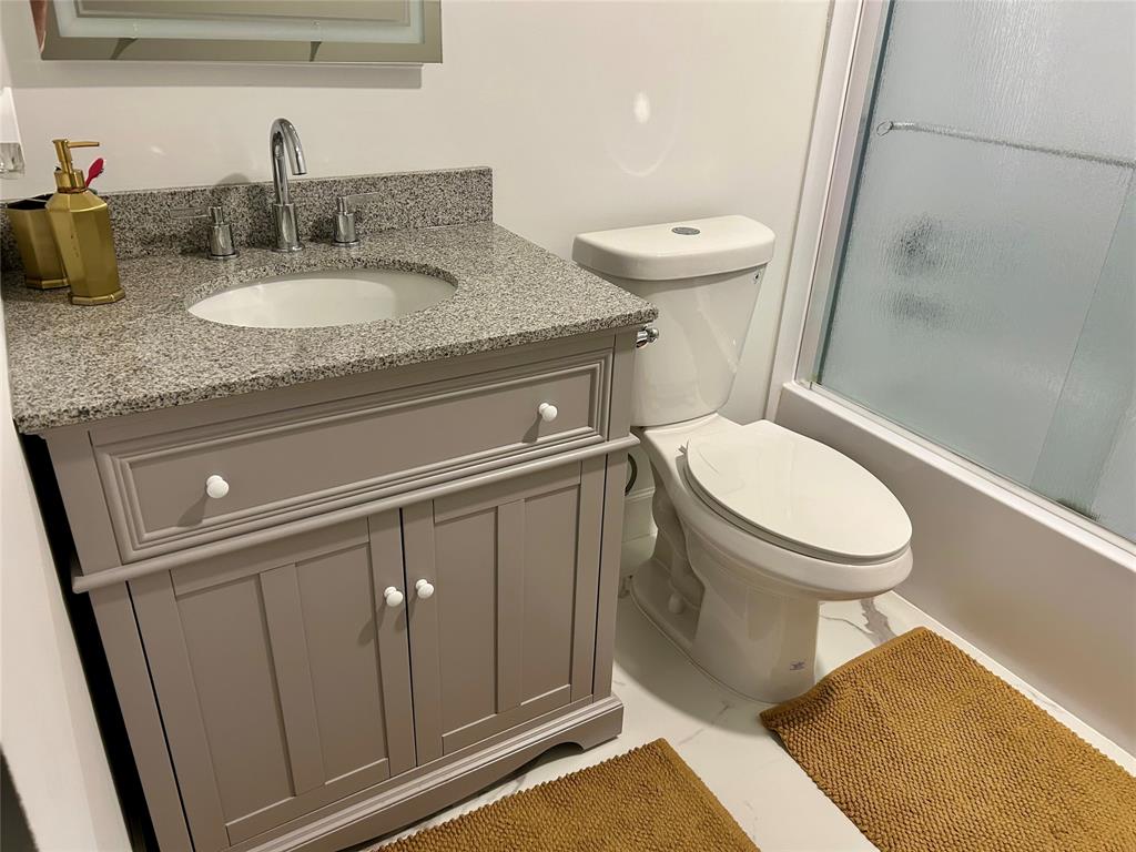 2151 Northeast 68th Street, Unit 226 Fort Lauderdale, FL 33308 - Photo 14 of 49 a bathroom with a granite countertop toilet sink and mirror