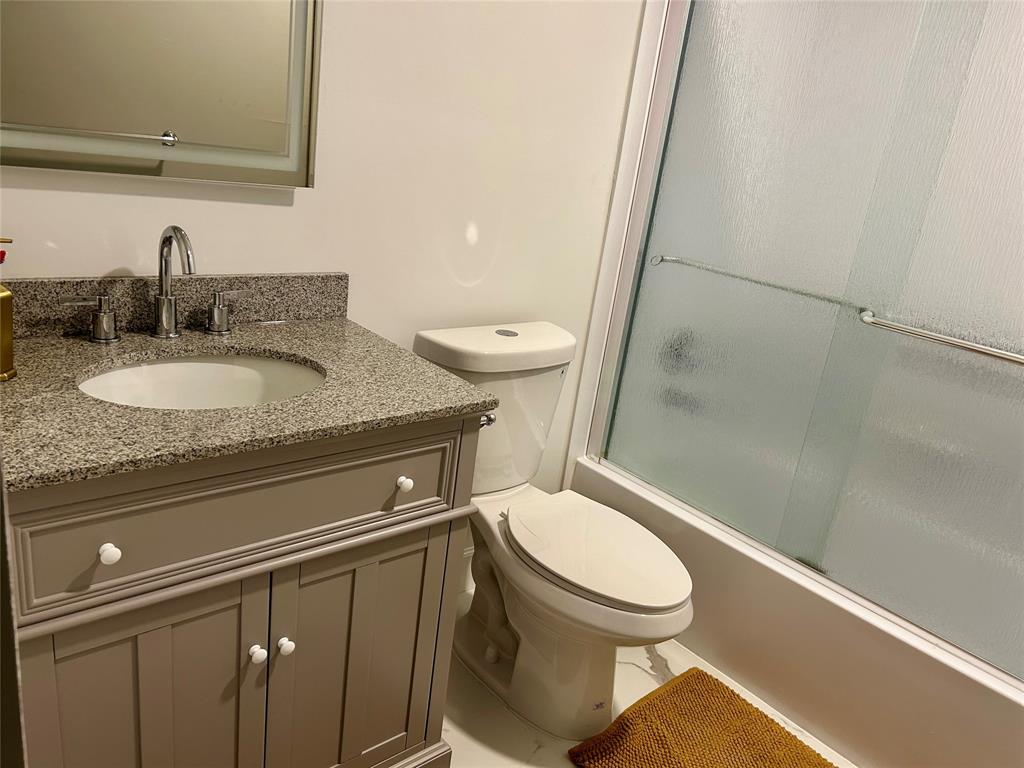2151 Northeast 68th Street, Unit 226 Fort Lauderdale, FL 33308 - Photo 17 of 49 a bathroom with a granite countertop toilet sink and mirror