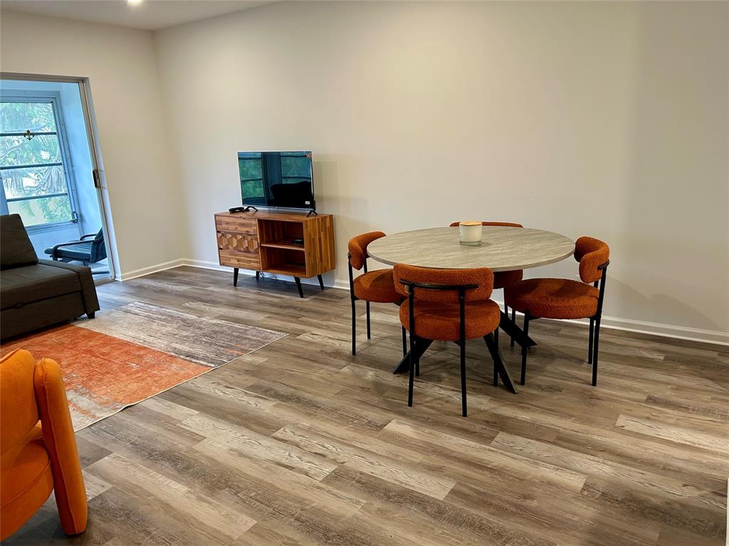 2151 Northeast 68th Street, Unit 226 Fort Lauderdale, FL 33308 - Photo 26 of 49 a living room with furniture and a flat screen tv