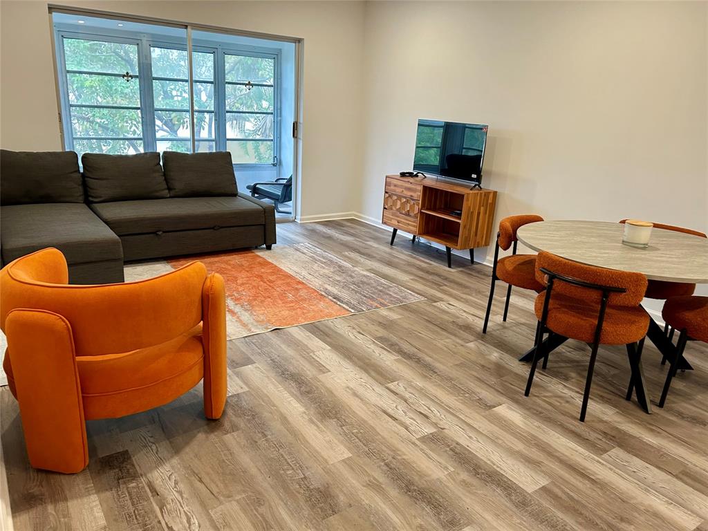 2151 Northeast 68th Street, Unit 226 Fort Lauderdale, FL 33308 - Photo 3 of 49 a living room with furniture and a flat screen tv