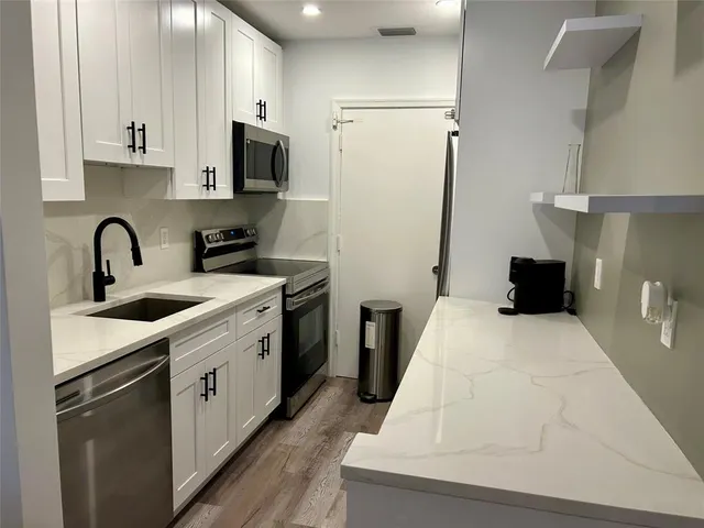 a kitchen with a sink a stove and refrigerator