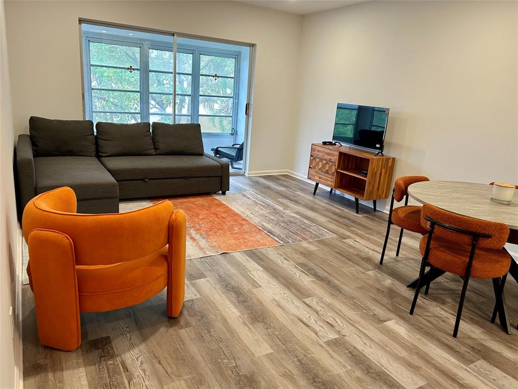 2151 Northeast 68th Street, Unit 226 Fort Lauderdale, FL 33308 - Photo 5 of 49 a living room with furniture and a flat screen tv