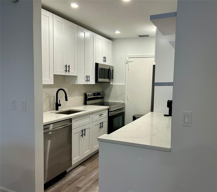 2151 Northeast 68th Street, Unit 226 Fort Lauderdale, FL 33308 - Photo 9 of 49 a kitchen with a sink a stove and refrigerator