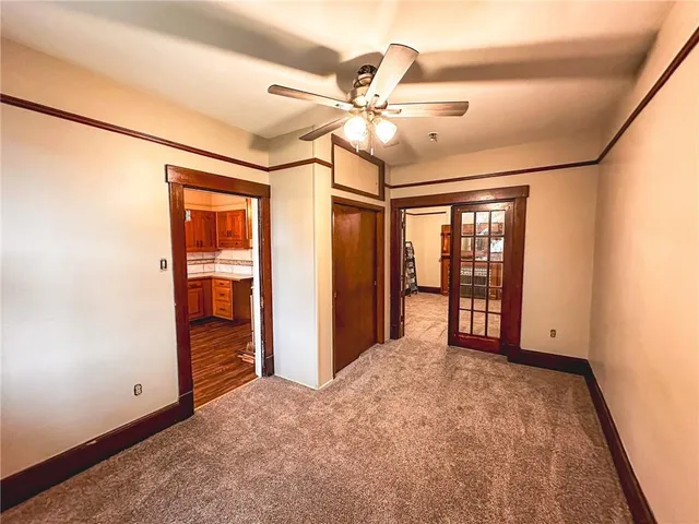 an empty room with fan and windows