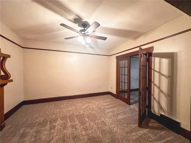 a view of a livingroom with a fireplace a ceiling fan and wooden floor