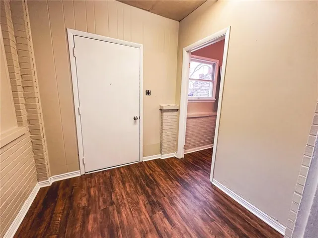 an empty room with wooden floor and entrance