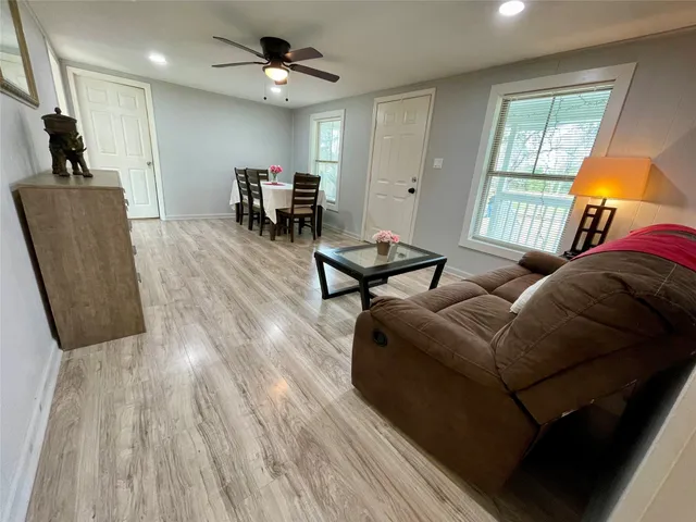 a kitchen with a refrigerator a stove a sink and a dining table with wooden floor