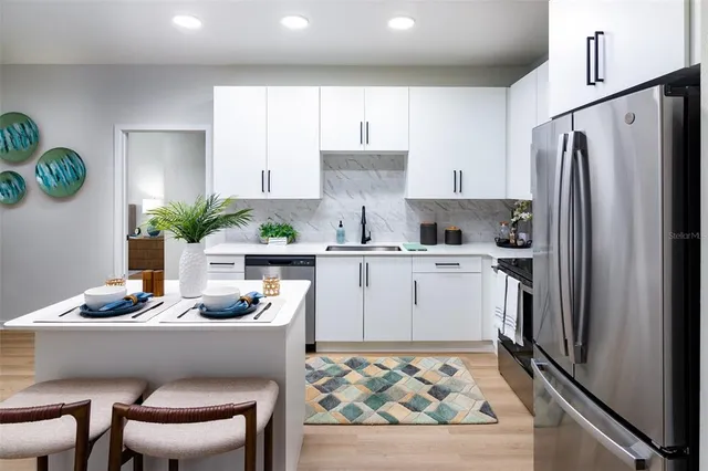 a kitchen with white cabinets and stainless steel appliances