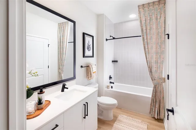 a bathroom with a sink a toilet and a large mirror