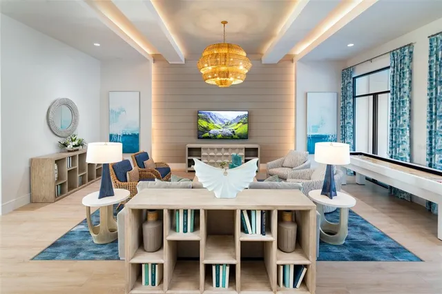 a dining room with wooden floor a chandelier a wooden table and chairs