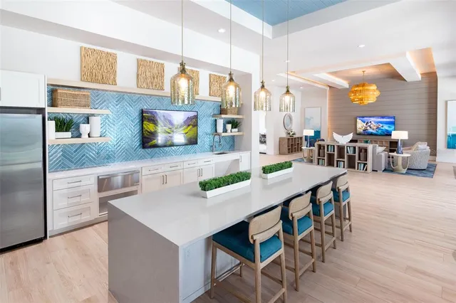 a kitchen with stainless steel appliances kitchen island granite countertop a table chairs in it and wooden floors