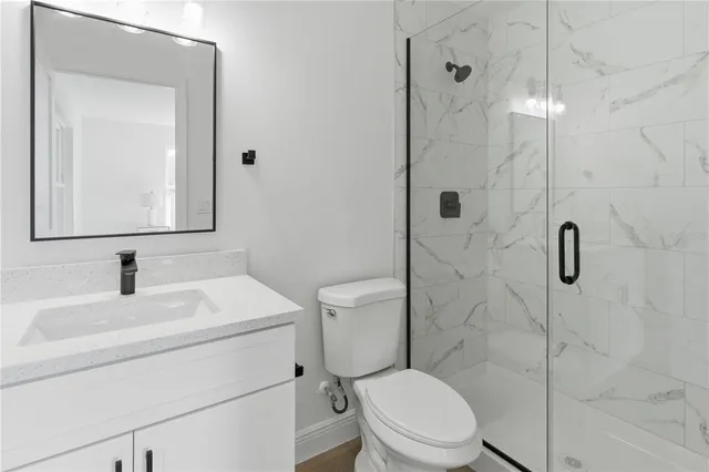 a bathroom with a toilet sink vanity and shower