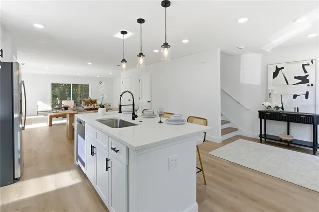 a kitchen with sink stove and refrigerator