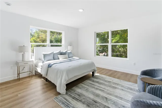 a bedroom with a bed and a large window