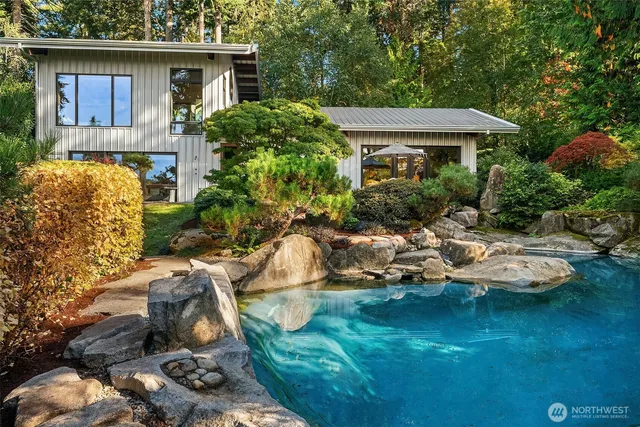 a view of a house with backyard sitting area and swimming pool