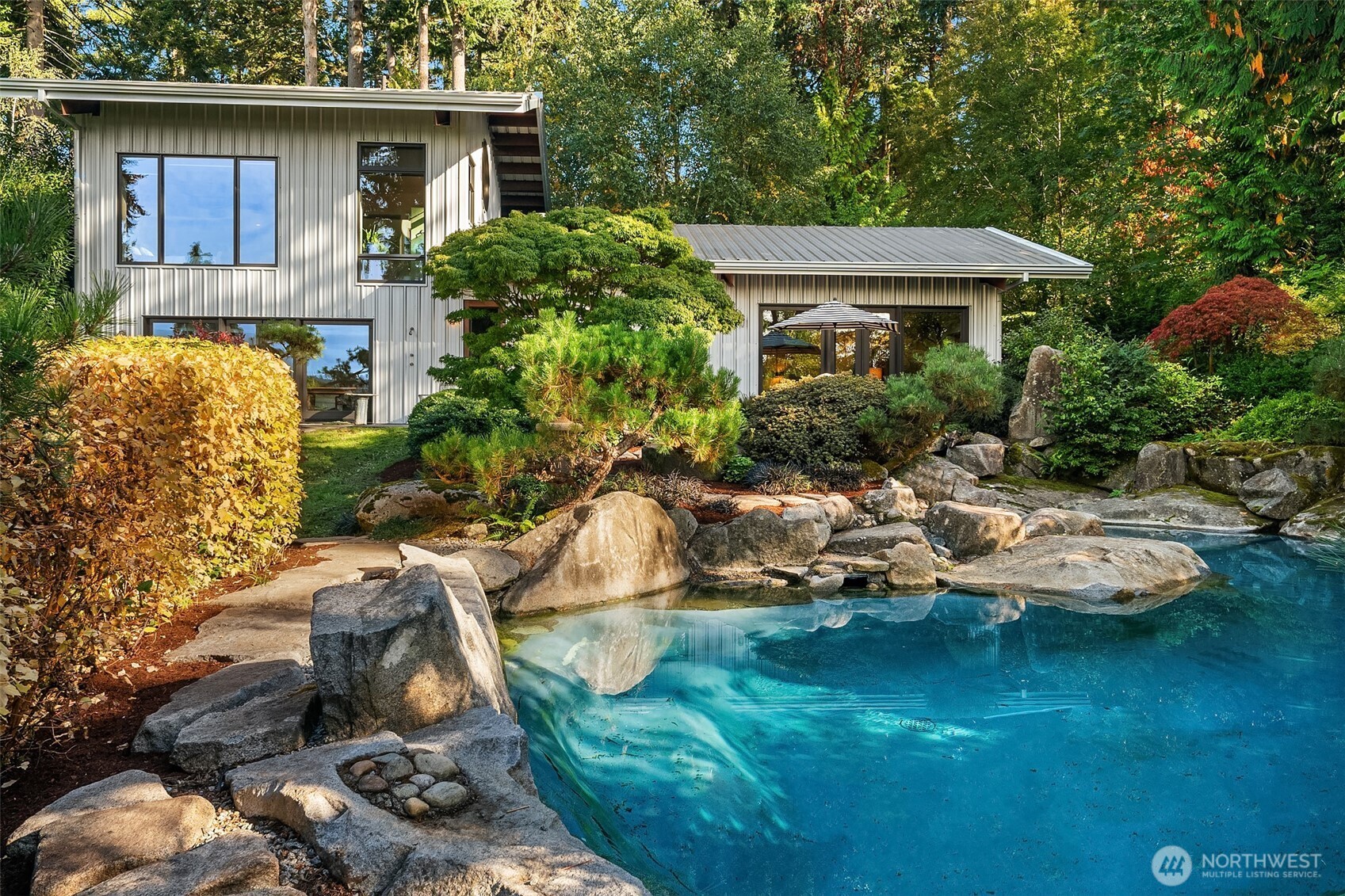 a view of a house with backyard sitting area and swimming pool
