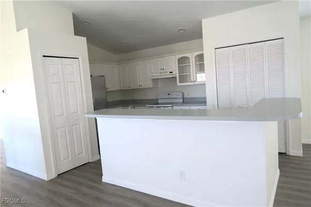 a kitchen with white cabinets and white appliances