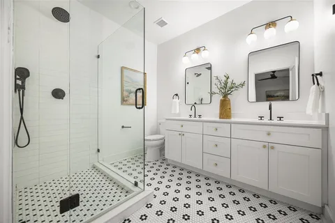 a bathroom with a sink a toilet and shower