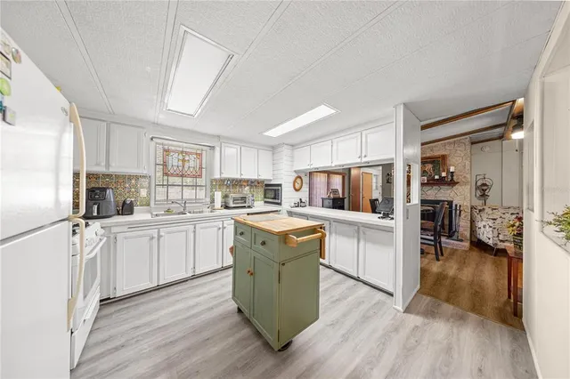 a kitchen with cabinets wooden floor and stainless steel appliances