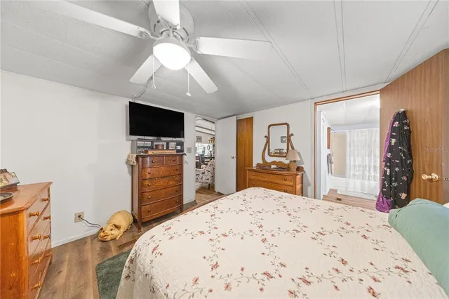 a bedroom with a bed and a flat tv screen on dresser