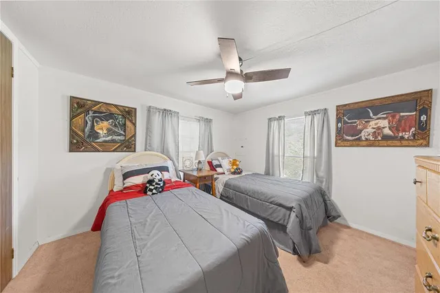a bedroom with two bed and a painting on the wall