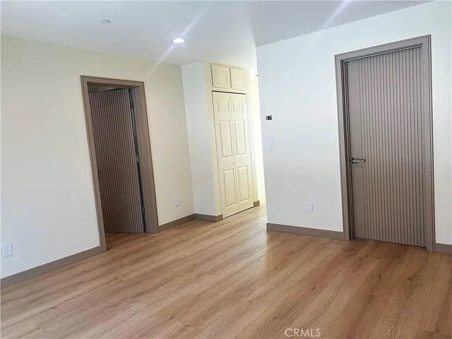 an empty room with wooden floor and closet