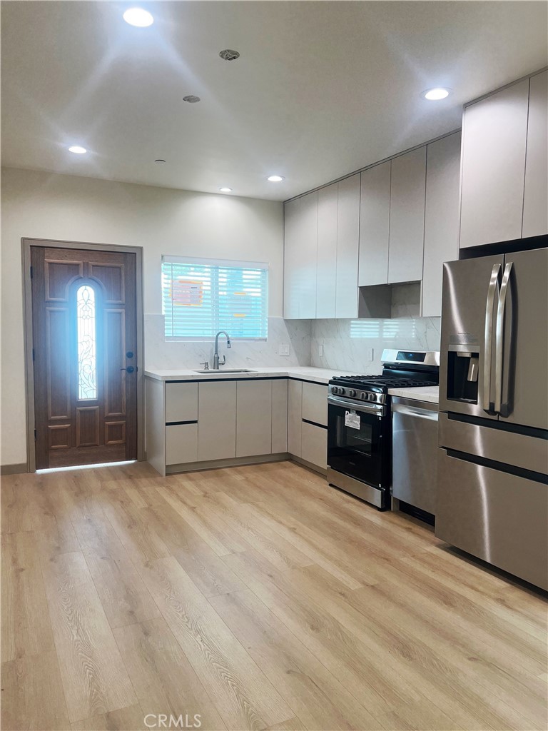 1514 East Woodbury Road, Unit 1/2 Pasadena, CA 91104 - Photo 3 of 14 a large kitchen with stainless steel appliances granite countertop a stove a sink and a refrigerator