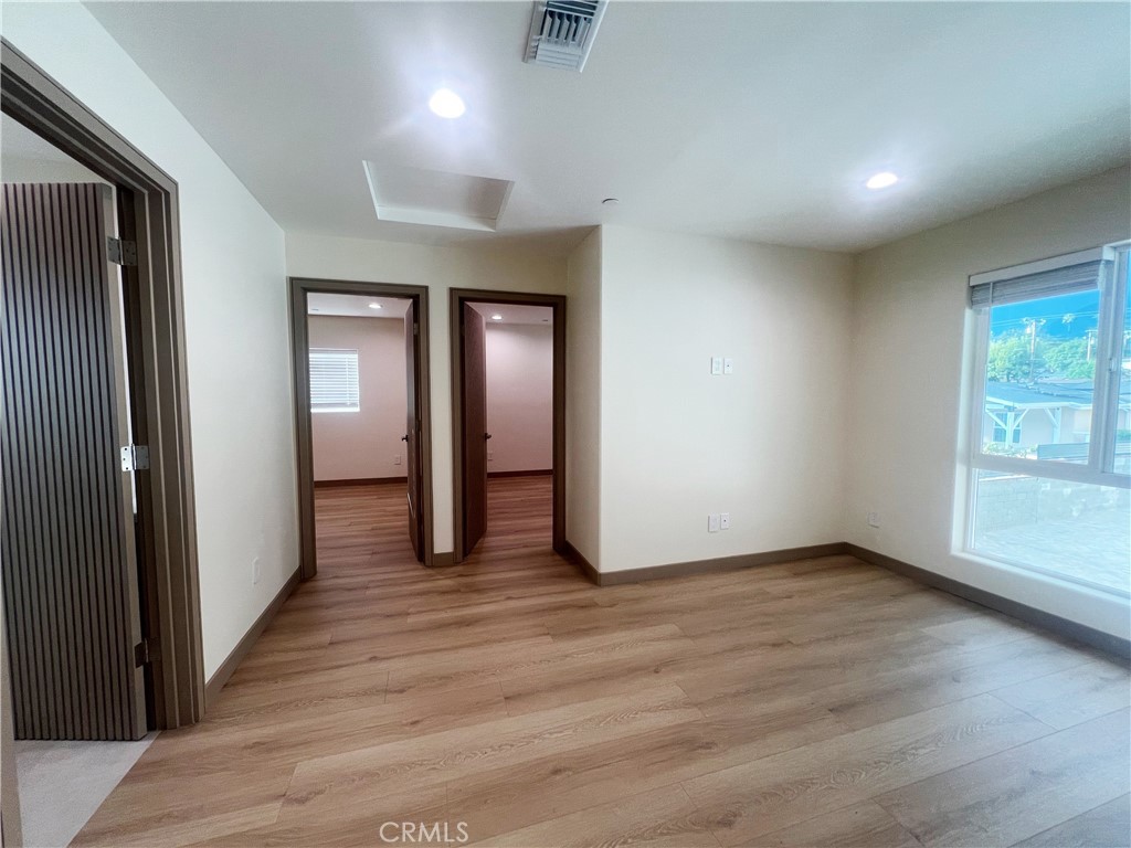1514 East Woodbury Road, Unit 1/2 Pasadena, CA 91104 - Photo 6 of 14 an empty room with wooden floor and windows