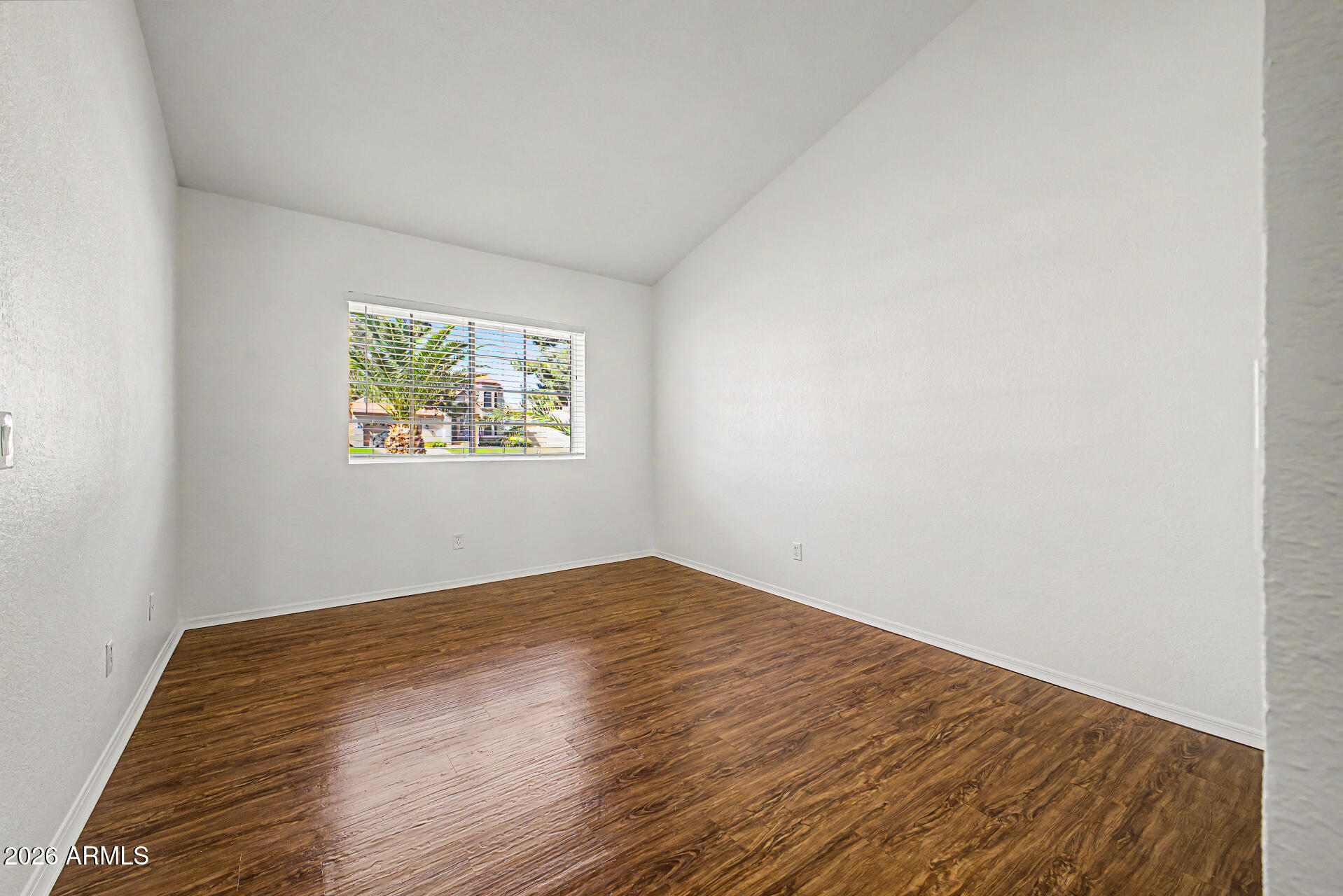 6725 West Utopia Road Glendale, AZ 85308 - Photo 19 of 27 an empty room with wooden floor and windows