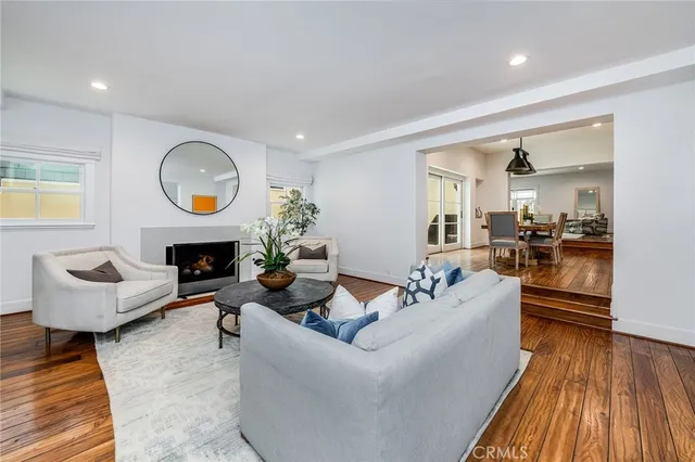 a living room with furniture a fireplace and a potted plant