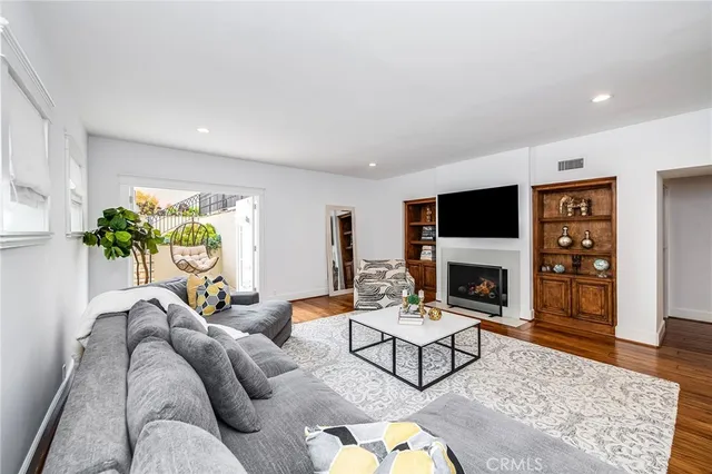 a view of a backyard with table and chairs potted plants and large tree