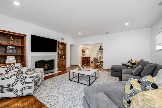 a view of a backyard with table and chairs potted plants and large tree