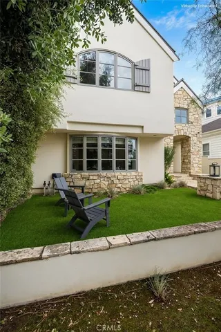 a front view of a house with a garden and plants