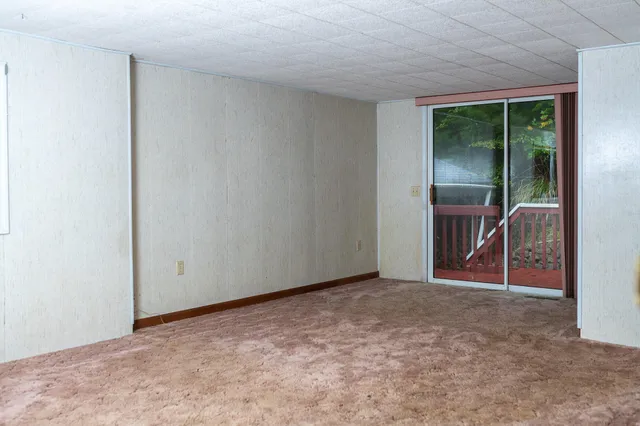 an empty room with closet and windows
