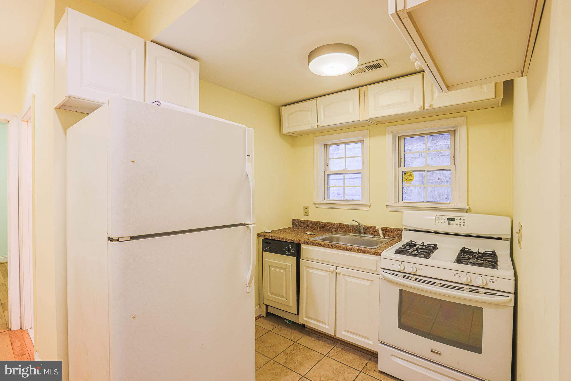 1447 William Street Baltimore, MD 21230 - Photo 30 of 72 a kitchen with a stove a refrigerator and a sink
